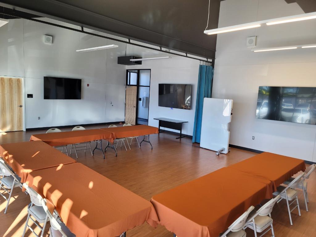 Community Engagement Center room showing tv's on the wall and a refridgerator